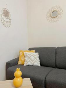 Modern Apartment Krakovska في براغ: غرفة معيشة مع أريكة رمادية مع مزهرية صفراء على طاولة