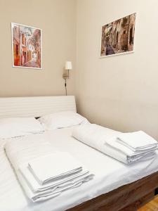 Modern Apartment Krakovska في براغ: سرير عليه شراشف بيضاء ومناشف