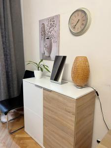 a desk with a clock on the wall and a chair at Modern Apartment Krakovska in Prague