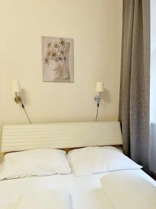 Modern Apartment Krakovska في براغ: غرفة نوم مع سرير مع مصباحين على الحائط
