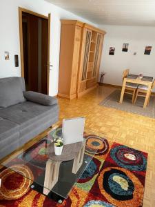 sala de estar con sofá y mesa con ordenador portátil. en Ferienwohnung am Waldrand mit Dachterrasse, en Wetter