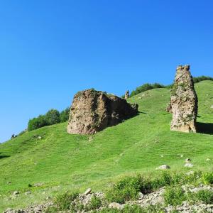 dwa duże formacje skalne na trawiastym wzgórzu w obiekcie Green Hostel w mieście Gorists'ikhe