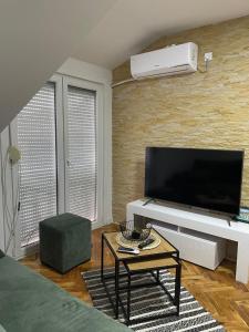 a living room with a large flat screen tv at Stan centar ns in Novi Sad