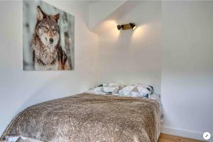 a bedroom with a bed with a picture of a wolf at Chalet Mirador appartement vue panoramique SITUÉ À 25 kms de CHAMONIX in Saint-Gervais-les-Bains