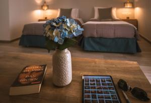 a table with a vase with flowers and a book at Sophies Greek Gateway in Kardamaina