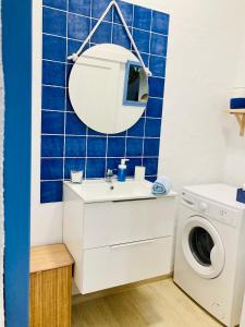 a bathroom with a washing machine and a sink at Casa Dora: Tradicional y al borde del mar. in Poris de Abona