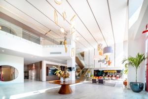 a lobby of a building with a table and flowers at Metria Hotel in León