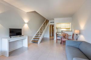 a living room with a staircase and a couch at Clube do Lago Hotel in Estoril