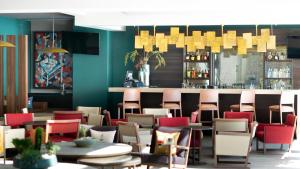 a restaurant with tables and chairs and a bar at Metria Hotel in León