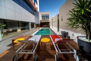 a patio with a table and chairs and a pool at Metria Hotel in León