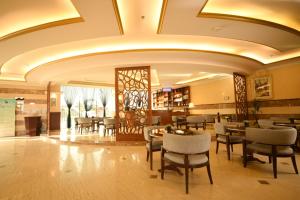 a restaurant with tables and chairs in a lobby at Hotel & Resort Golden Marina Yanbu in Yanbu