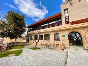 un edificio con patio y sillas frente a él en El Bulín de Madarcos, en Madarcos