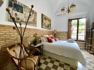 - une chambre avec un lit et un mur en briques dans l'établissement Casa Palacio Ánima, à Jerez de la Frontera