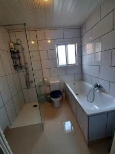 a bathroom with a tub and a toilet and a sink at Vistas al lago with private pool in Viñuela