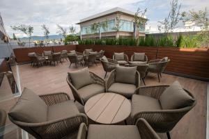 a patio with couches and tables and chairs at Metria Hotel in León