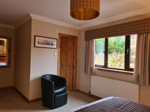 a bedroom with a chair and a window at Creag-Ard Bed & Breakfast,with private lounge in Dundonnell