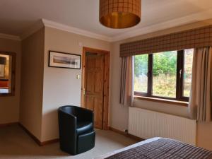 a bedroom with a chair and a window at Creag-Ard Bed & Breakfast in Dundonnell