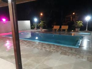 a swimming pool in the middle of a patio at night at Sítio Toa Toa in São Roque