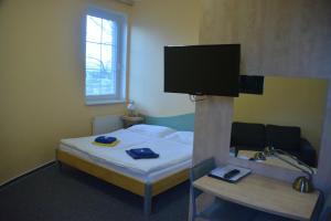 1 dormitorio con 1 cama y TV de pantalla plana en Penzion ve věži, en Bohumín