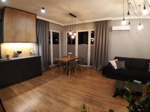 cocina y sala de estar con mesa y sofá. en Lux-house Braniewo, en Braniewo