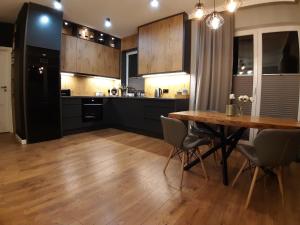 cocina con mesa de madera y comedor en Lux-house Braniewo, en Braniewo