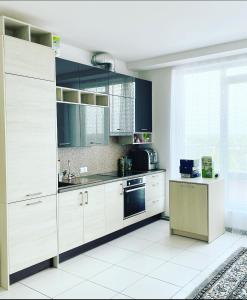 uma cozinha com armários brancos e um lavatório em Jaunā Teika Penthouse em Riga