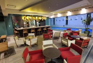a restaurant with tables and chairs and a bar at Metria Hotel in León