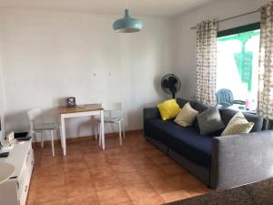 プエルト・デル・カルメンにあるLittle Gem Lanzaroteのリビングルーム(青いソファ、テーブル付)
