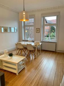 a living room with a table and chairs and windows at Villa Wakenitz in Lübeck