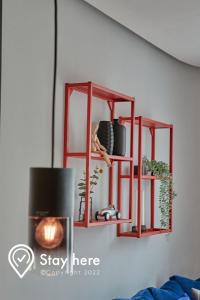 a red shelf hanging on a wall with plants at Stayhere Casablanca - Palmier - Executive Residence in Casablanca