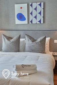 - un lit avec des draps et des oreillers blancs dans l'établissement Stayhere Casablanca - Palmier - Executive Residence, à Casablanca