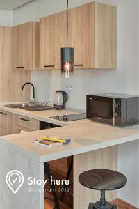 a kitchen with a counter with a microwave and a stool at Stayhere Casablanca - Palmier - Executive Residence in Casablanca