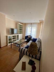 uma sala de estar com um sofá e uma mesa em Apartamento Marexada Foz em Foz
