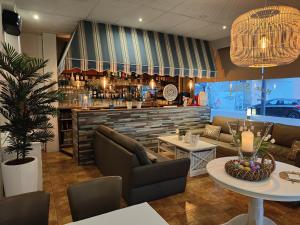 ein Restaurant mit einer Bar mit Sofas und einem Tisch in der Unterkunft Hotel Sfinx in De Panne