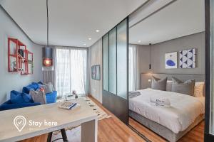 Stayhere Casablanca - Palmier - Executive Residence في الدار البيضاء: غرفة نوم بسرير كبير وأريكة زرقاء