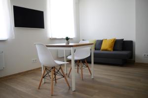 a living room with a table and two chairs and a couch at City center apartment in Klaipėda
