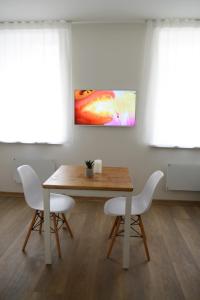 a dining room with a table and white chairs at City center apartment in Klaipėda