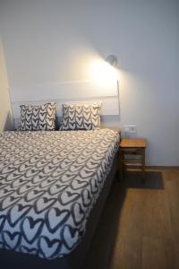 a bedroom with a bed and a lamp and a table at City center apartment in Klaipėda