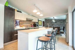 a kitchen with a counter and stools at a bar at Spectacular House Tulipanes in Xochitepec +21 photos