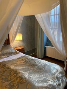 1 dormitorio con cama, lámpara y ventana en Maison de l'Aumance, en Meaulne