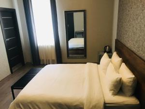a bedroom with a white bed and a mirror at 2nd Floor Hotel in Tbilisi City