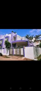een groot wit huis met paarse rand bij PRAVESH VILLA in Pondicherry