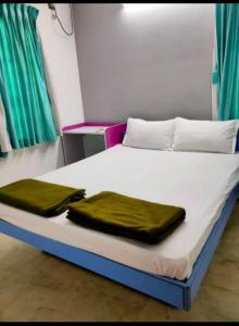 uma cama com dois cobertores verdes em PRAVESH VILLA em Pondicherry