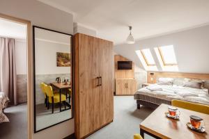 a bedroom with a bed and a dining room with a table at Kosówka Czarna Góra in Stronie Śląskie