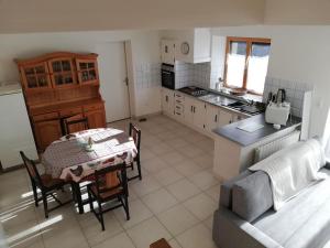 a kitchen and dining room with a table and a couch at La maison des chevreuils in Plouigneau
