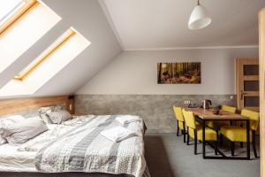 sypialnia z łóżkiem i stołem z żółtymi krzesłami w obiekcie Kosówka Czarna Góra w Stroniu Śląskim