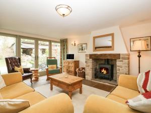 a living room with a fireplace and couches at Timber Barn in Eardisland