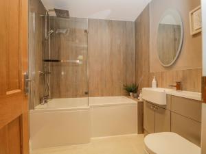 a bathroom with a shower and a tub and a toilet at Garden Cottage in Keswick +11 photos