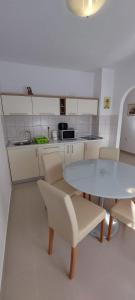 cocina con mesa, sillas y barra en Apartment Viki, en Zadar
