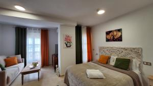 a bedroom with a large bed and a couch at Estudios Costavigía Mazagón by Ramona in Mazagón